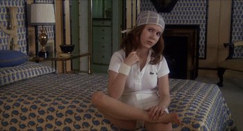 Movie still from “Shampoo” (1975), directed by Hal Ashby – A woman sitting on the ground wearing a white outfit; Medium shot, High angle