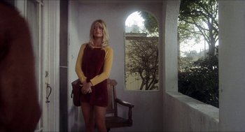 Movie still from “Shampoo” (1975), directed by Hal Ashby – A woman standing on a chair in front of an arched window; Medium shot, Low angle