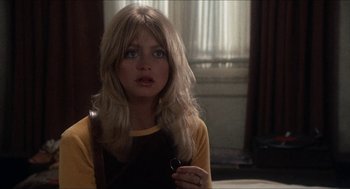 Movie still from “Shampoo” (1975), directed by Hal Ashby – A woman with long blonde hair wearing a yellow and black shirt; Close Up shot, Over the shoulder angle