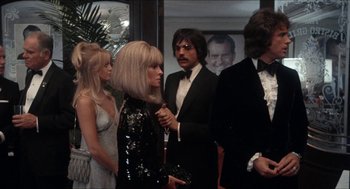 Movie still from “Shampoo” (1975), directed by Hal Ashby – A group of people standing next to each other in a room; Medium shot, Low angle