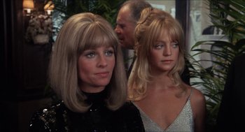 Movie still from “Shampoo” (1975), directed by Hal Ashby – Two women with blonde hair and a man in the background; Close Up shot, Over the shoulder angle
