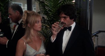 Movie still from “Shampoo” (1975), directed by Hal Ashby – A man and a woman drinking champagne at a party; Close Up shot, Over the shoulder angle
