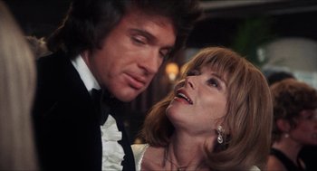 Movie still from “Shampoo” (1975), directed by Hal Ashby – A man and a woman in formal wear looking at each other; Close Up shot, Low angle