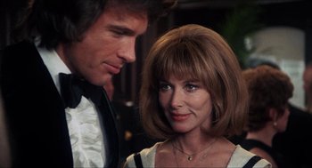 Movie still from “Shampoo” (1975), directed by Hal Ashby – A man standing next to a woman wearing a white dress; Close Up shot, Over the shoulder angle