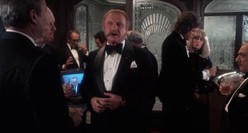 Movie still from “Shampoo” (1975), directed by Hal Ashby – An older man wearing a tuxedo and a bow tie; Medium shot, Low angle