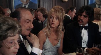 Movie still from “Shampoo” (1975), directed by Hal Ashby – A man and a woman sitting at a dinner table; Medium shot, Over the shoulder angle