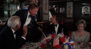 Movie still from “Shampoo” (1975), directed by Hal Ashby – Two men in tuxedos sitting at a dinner table; Medium shot, Over the shoulder angle