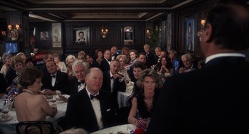 Movie still from “Shampoo” (1975), directed by Hal Ashby – A group of people sitting at a table in a room; Wide shot, Over the shoulder angle