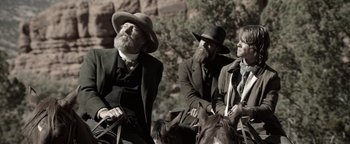 Movie still from “Godless” (2017), directed by Scott Frank – Two men on horseback in a western setting; Medium shot, Over the shoulder angle