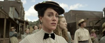 Movie still from “Godless” (2017), directed by Scott Frank – A person wearing a hat and a bow tie; Close Up shot, Over the shoulder angle