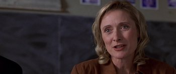 Movie still from “Shattered Glass” (2003), directed by Billy Ray – An older woman with blonde hair is looking at the camera; Close Up shot, Over the shoulder angle