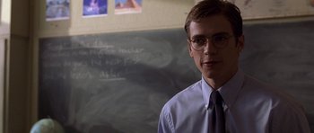 Movie still from “Shattered Glass” (2003), directed by Billy Ray – A man in a tie standing in front of a chalkboard; Close Up shot, Over the shoulder angle