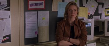 Movie still from “Shattered Glass” (2003), directed by Billy Ray – A woman standing in front of a wall with papers on the wall; Medium shot, Over the shoulder angle