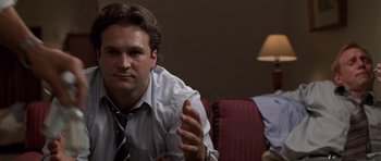 Movie still from “Shattered Glass” (2003), directed by Billy Ray – A man sitting in front of another man in front of a couch; Close Up shot, Over the shoulder angle