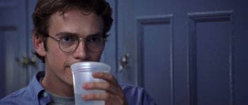 Movie still from “Shattered Glass” (2003), directed by Billy Ray – A man with glasses is drinking a cup of water; Close Up shot, Over the shoulder angle