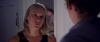 Movie still from “Shattered Glass” (2003), directed by Billy Ray – A woman looking into a mirror while standing next to a wall; Close Up shot, Over the shoulder angle