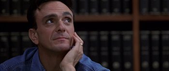 Movie still from “Shattered Glass” (2003), directed by Billy Ray – A person sitting in front of a book shelf; Close Up shot, Low angle