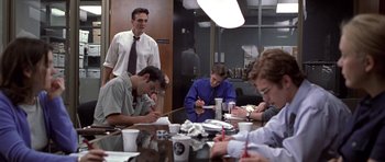 Movie still from “Shattered Glass” (2003), directed by Billy Ray – A group of people sitting at a table writing; Medium shot, Over the shoulder angle