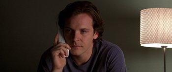Movie still from “Shattered Glass” (2003), directed by Billy Ray – A young man holding a cell phone up to his ear; Close Up shot, Low angle