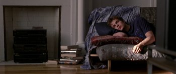 Movie still from “Shattered Glass” (2003), directed by Billy Ray – A man laying on a bed with a bunch of books; Wide shot, High angle