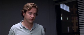 Movie still from “Shattered Glass” (2003), directed by Billy Ray – A man with long brown hair wearing a white shirt; Close Up shot, Over the shoulder angle