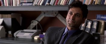 Movie still from “Shattered Glass” (2003), directed by Billy Ray – A man sitting in front of a bookshelf in a room; Close Up shot, Over the shoulder angle