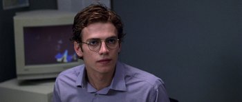 Movie still from “Shattered Glass” (2003), directed by Billy Ray – A young man wearing glasses and a purple shirt; Close Up shot, Over the shoulder angle