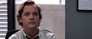 Movie still from “Shattered Glass” (2003), directed by Billy Ray – A person sitting in a chair; Close Up shot, Low angle