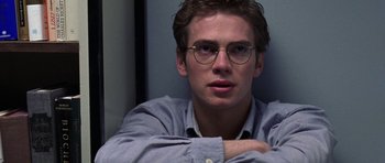 Movie still from “Shattered Glass” (2003), directed by Billy Ray – A man with glasses sitting in front of a wall; Close Up shot, Over the shoulder angle