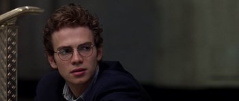 Movie still from “Shattered Glass” (2003), directed by Billy Ray – A young man wearing glasses sitting in a room; Close Up shot, Over the shoulder angle