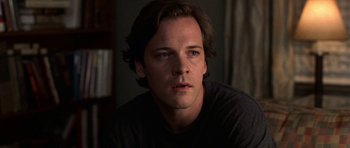 Movie still from “Shattered Glass” (2003), directed by Billy Ray – A person with long brown hair; Close Up shot, Over the shoulder angle