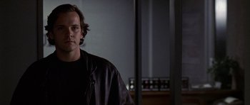 Movie still from “Shattered Glass” (2003), directed by Billy Ray – A man wearing a leather jacket standing in front of a window; Close Up shot, Low angle