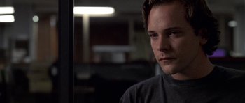Movie still from “Shattered Glass” (2003), directed by Billy Ray – A young man is sitting in a dark room; Close Up shot, Over the shoulder angle
