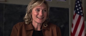 Movie still from “Shattered Glass” (2003), directed by Billy Ray – A person wearing a brown jacket smiling; Close Up shot, Over the shoulder angle