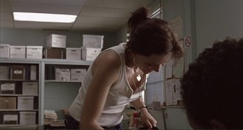 Movie still from “Sherrybaby” (2006), directed by Laurie Collyer – A woman standing in front of boxes in an office; Medium shot, Over the shoulder angle