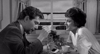 Movie still from “Ship of Fools” (1965), directed by Stanley Kramer – A man and a woman sitting at a table; Medium shot, Over the shoulder angle