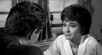 Movie still from “Ship of Fools” (1965), directed by Stanley Kramer – A woman sitting next to a man in a room; Close Up shot, Over the shoulder angle