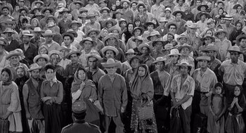 Movie still from “Ship of Fools” (1965), directed by Stanley Kramer – A large group of men and women wearing hats; Wide shot, High angle