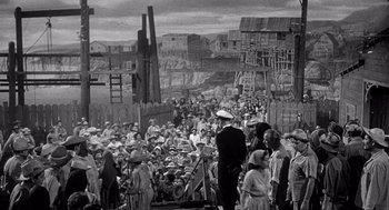 Movie still from “Ship of Fools” (1965), directed by Stanley Kramer – A crowd of people standing in front of a building; Extreme Wide shot, High angle