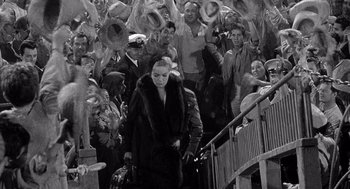 Movie still from “Ship of Fools” (1965), directed by Stanley Kramer – A woman in a fur coat walking down a flight of stairs; Wide shot, High angle