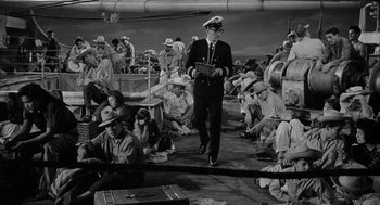 Movie still from “Ship of Fools” (1965), directed by Stanley Kramer – A man in a uniform walking on a boat; Wide shot, High angle