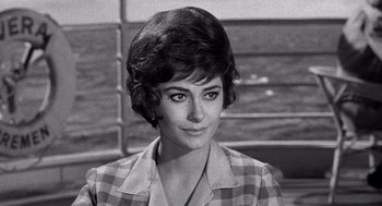 Movie still from “Ship of Fools” (1965), directed by Stanley Kramer – A black - and - white photo of a woman in a checkered jacket; Close Up shot, Over the shoulder angle