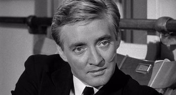 Movie still from “Ship of Fools” (1965), directed by Stanley Kramer – Black and white photograph of a man in a suit and tie; Close Up shot, High angle