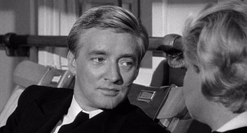 Movie still from “Ship of Fools” (1965), directed by Stanley Kramer – A black and white photo of a man in a suit and tie; Close Up shot, Over the shoulder angle