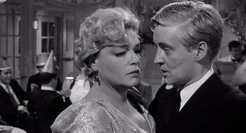 Movie still from “Ship of Fools” (1965), directed by Stanley Kramer – An older woman standing next to a younger man; Close Up shot, Over the shoulder angle