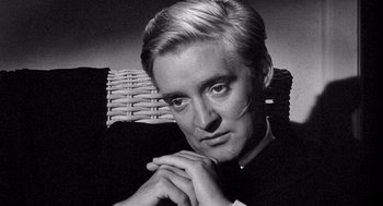 Movie still from “Ship of Fools” (1965), directed by Stanley Kramer – Black and white photograph of a man with his hands folded on his chest; Close Up shot, Low angle