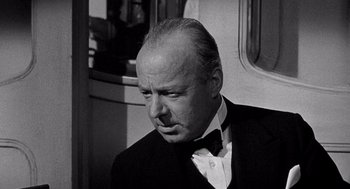 Movie still from “Ship of Fools” (1965), directed by Stanley Kramer – An older man wearing a suit and bow tie; Close Up shot, Low angle