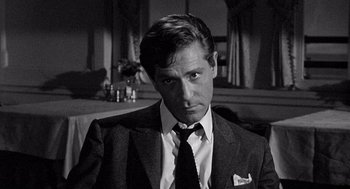 Movie still from “Ship of Fools” (1965), directed by Stanley Kramer – Black and white photograph of a man wearing a suit and tie; Close Up shot, Over the shoulder angle