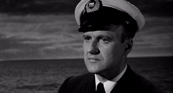 Movie still from “Ship of Fools” (1965), directed by Stanley Kramer – A man wearing a hat and a uniform; Close Up shot, Low angle