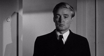 Movie still from “Ship of Fools” (1965), directed by Stanley Kramer – Black and white photograph of a man in a suit; Close Up shot, Over the shoulder angle